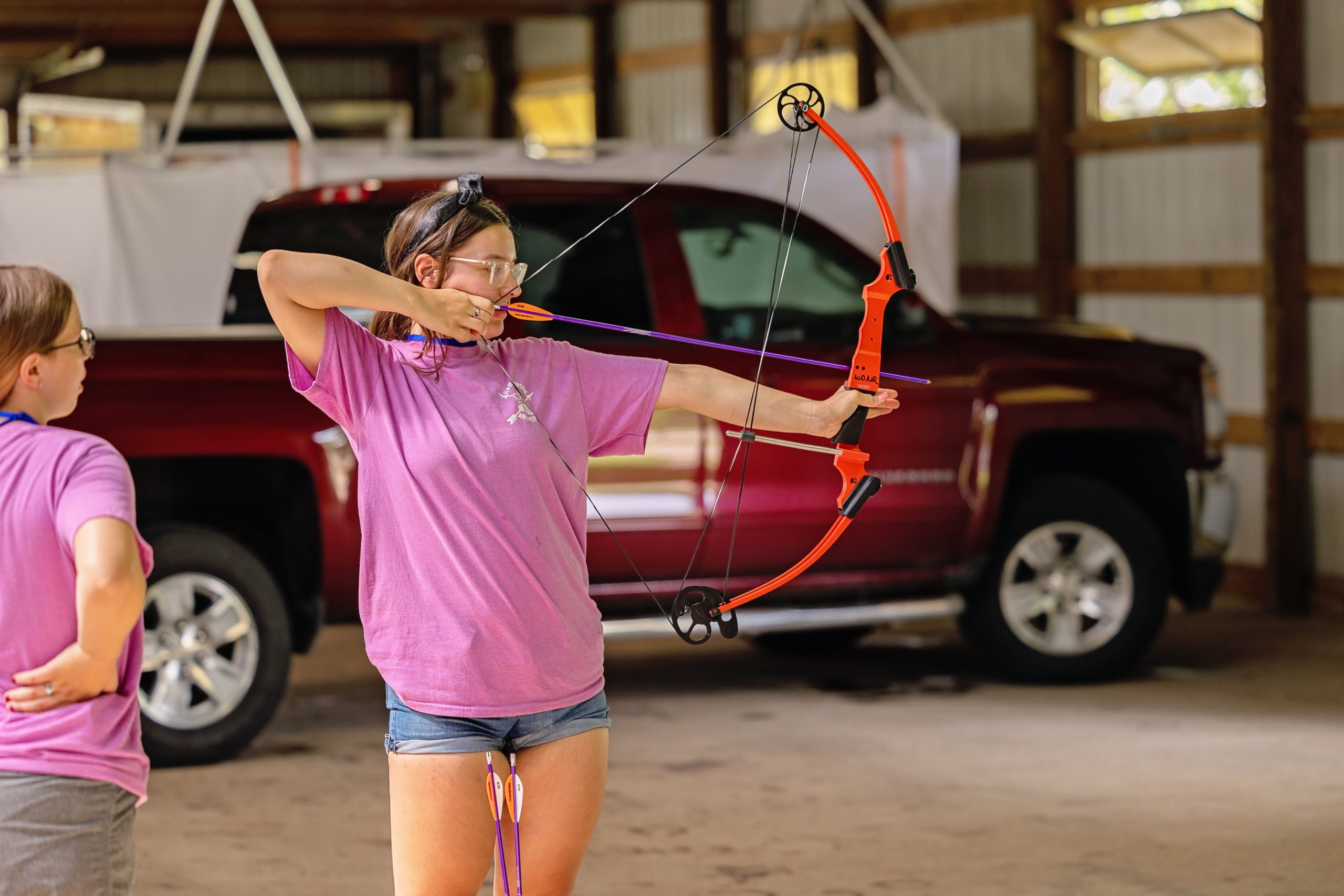 A young lady reaches full draw…